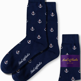 The Anchor Socks by AusCufflinks, featuring navy blue with white anchor patterns, exude nautical charm as they are elegantly laid out next to their packaging.