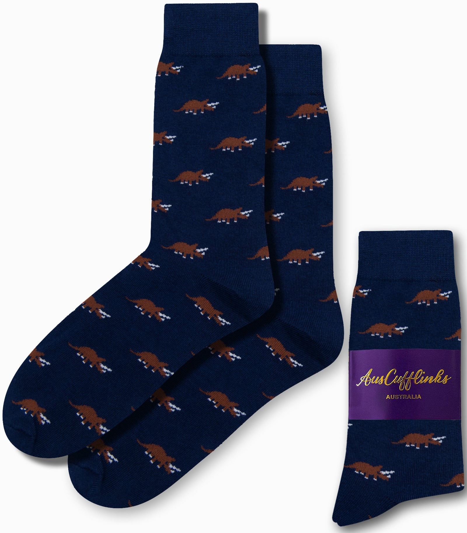 The Triceratops Socks in navy blue display a stylish pattern of brown triceratops dinosaurs, offering a touch of prehistoric elegance and are elegantly packaged with a purple label.