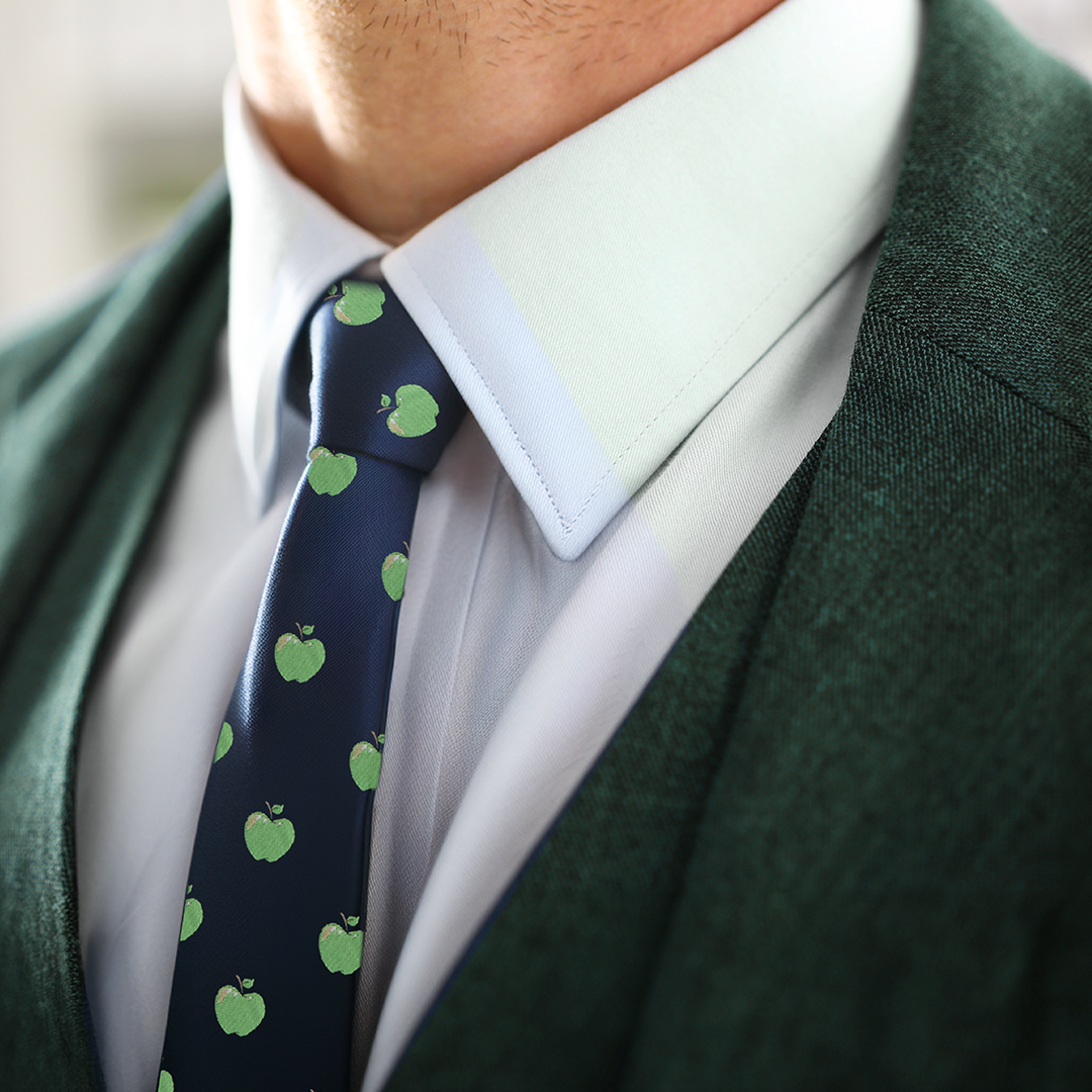 Close-up of a person wearing a green suit jacket, a white shirt, and an Apple Skinny Tie, showcasing modern style and natural freshness.