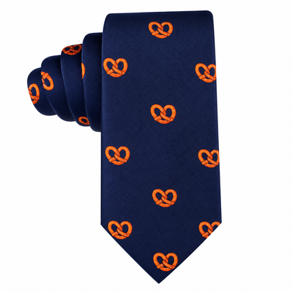 The Bagel Skinny Tie showcases a navy blue background adorned with a repeating pattern of small orange pretzels, offering a quirky and playful accessory that’s perfect for food enthusiasts who appreciate bagel-inspired designs.