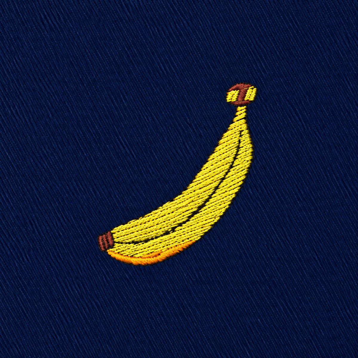 Add a playful touch to your Banana Skinny Tie with this embroidered yellow banana featuring brown tips on a dark blue fabric background, or use it as inspiration for a unique tropical print tie.