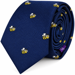 Introducing the Bee Skinny Tie: a rolled-up navy blue tie adorned with a scattering of small yellow and black bee motifs across the fabric.