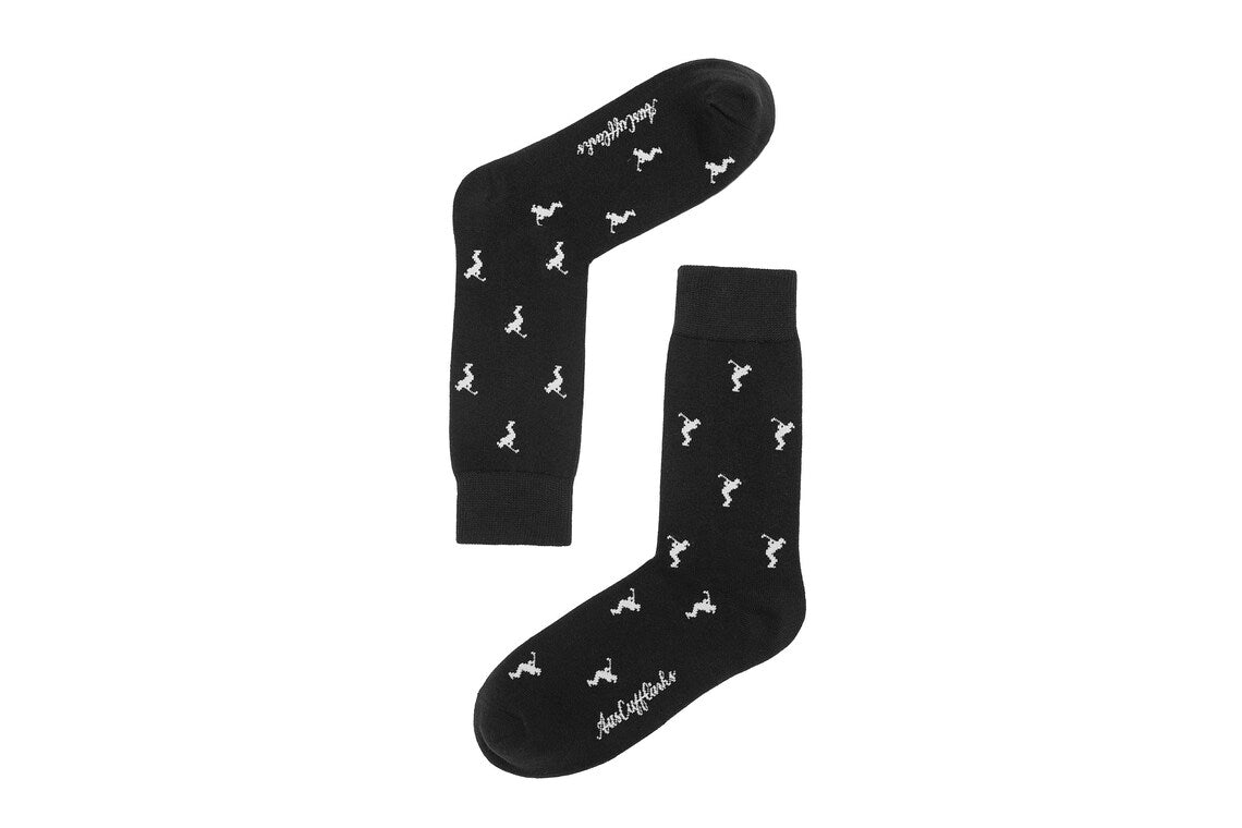 Golf Swing Black Socks feature a black base with small white dinosaur silhouettes and white text by the toe—ideal for quirky style on the course or as a fun golf gift.