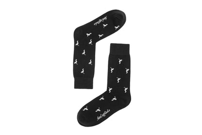 Golf Swing Black Socks feature a black base with small white dinosaur silhouettes and white text by the toe—ideal for quirky style on the course or as a fun golf gift.