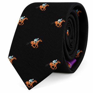 The Horse Racing Skinny BLACK Tie features a repeating pattern of orange jockeys riding horses on a sleek black background, shown rolled up to highlight its unique design—a standout accessory for horse racing enthusiasts and style connoisseurs.