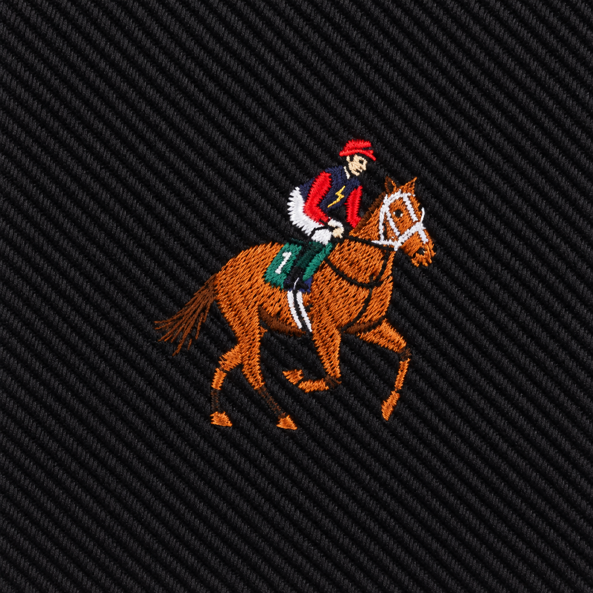 Embroidered with a jockey in red and white gear riding a brown horse on dark textured fabric, the Black Thoroughbred Racing Horse Skinny Tie is perfect for accenting any equestrian or horse racing ensemble.