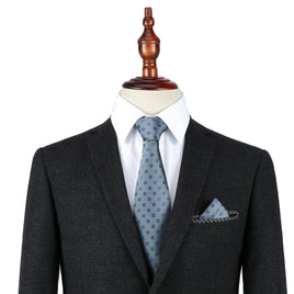 A mannequin dressed in a dark suit, white shirt, and a Blue Flower Grey Business Tie & Pocket Square Set.