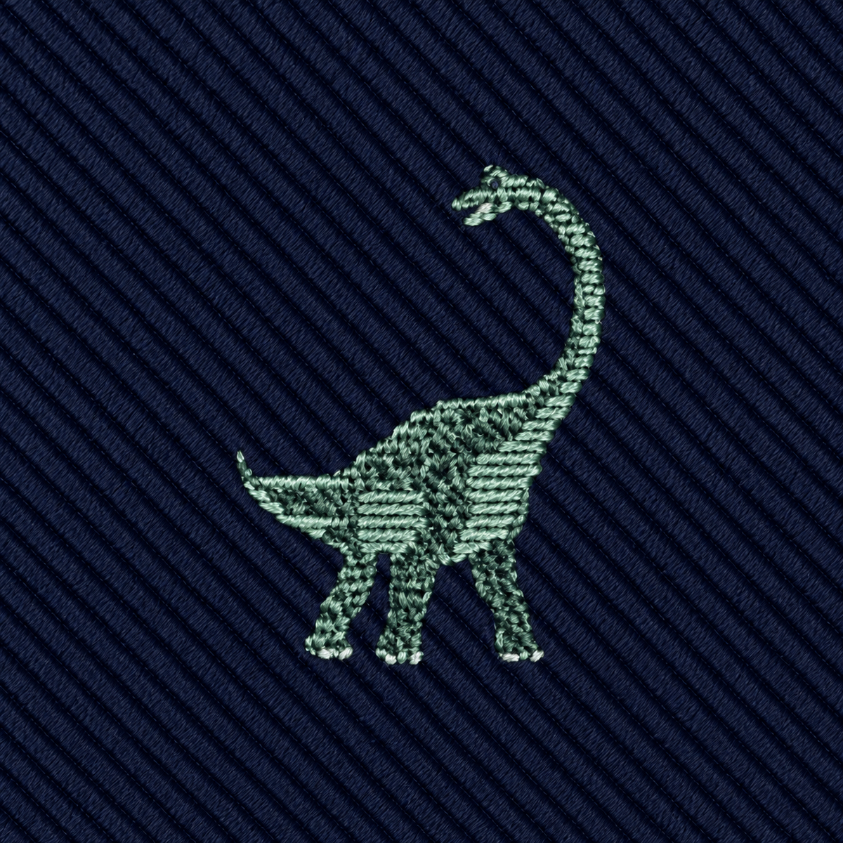 A green embroidered brontosaurus decorates this Brontosaurus Skinny Tie, which features a dark blue, diagonally ribbed fabric background.