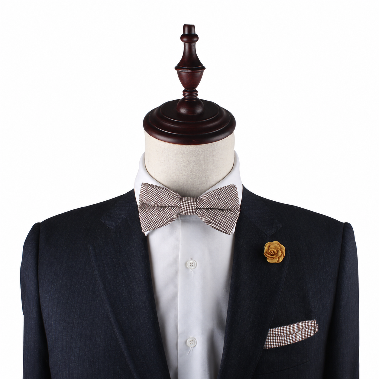 A mannequin displays the Brown Mini Houndstooth Pocket Square, paired with a dark suit, white shirt, light bow tie, and yellow flower lapel pin, highlighting elegant wedding accessories against a white background.