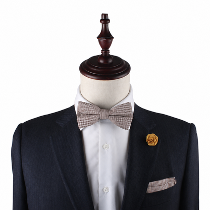 A mannequin displays the Brown Mini Houndstooth Pocket Square, paired with a dark suit, white shirt, light bow tie, and yellow flower lapel pin, highlighting elegant wedding accessories against a white background.