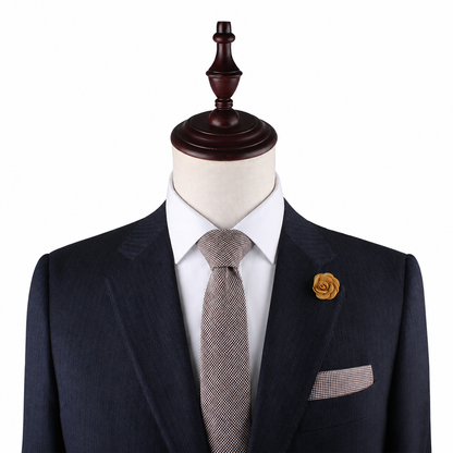 A mannequin showcases the Brown Mini Houndstooth Pocket Square, styled with a dark suit, white shirt, patterned tie, and yellow flower lapel pin—ideal for highlighting sophisticated wedding accessories—against a plain white background.