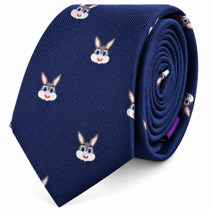 The Bunny Skinny Tie is a rolled blue novelty skinny tie decorated with a repeating pattern of cartoon rabbit faces, complete with big eyes, pink ears, and cheerful smiles. This playful accessory adds a fun animal print element to your outfit.