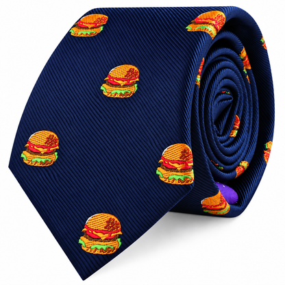 Introducing the Burger Skinny Tie: a navy blue skinny tie adorned with a playful, repeating pattern of embroidered cheeseburgers stacked with lettuce, tomato, and cheese—an ideal foodie gift for anyone who enjoys adding a fun twist to classic style.