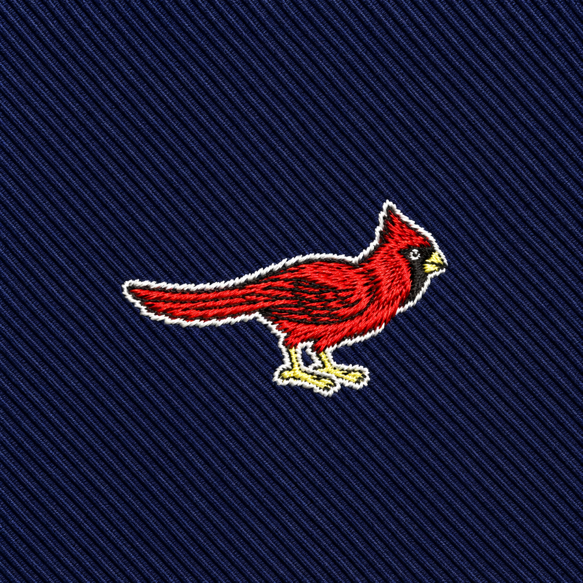 Featuring an embroidered red cardinal bird set against a dark blue, diagonal-striped fabric background, the Cardinal Bird Skinny Tie makes an ideal addition to any wildlife-inspired fashion collection.