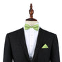 A black suit is displayed on a mannequin with a white dress shirt, a Classic Lime Green Bow Tie, and a matching pocket square.