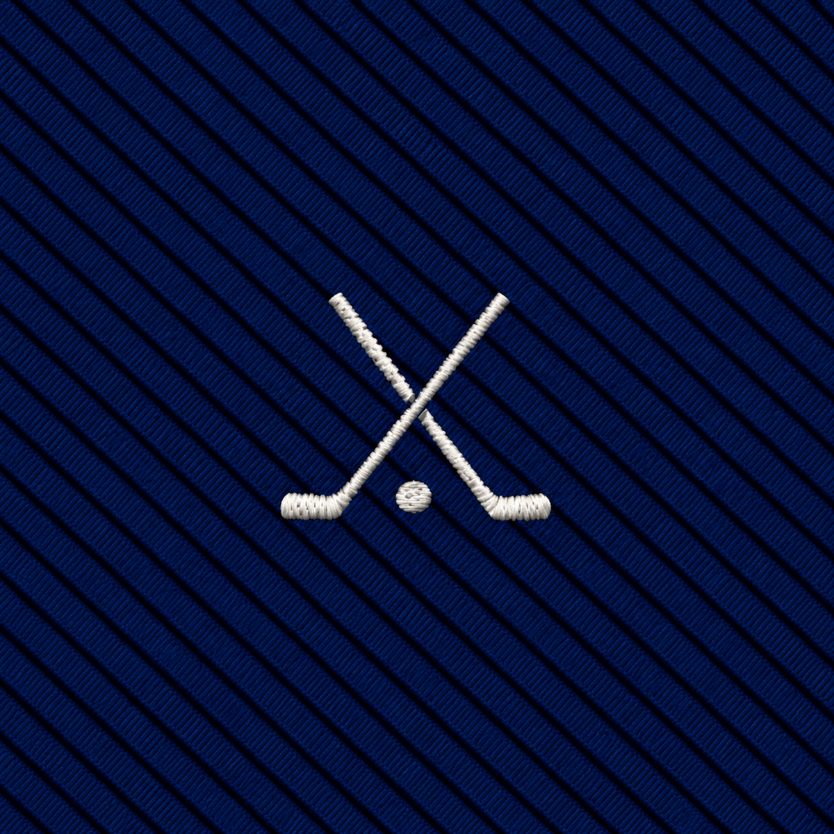 Two crossed ice hockey sticks and a puck embroidered in white on a dark blue diagonally striped fabric background, offering the same refined appeal as a novelty golf tie, but with a classic ice hockey twist.