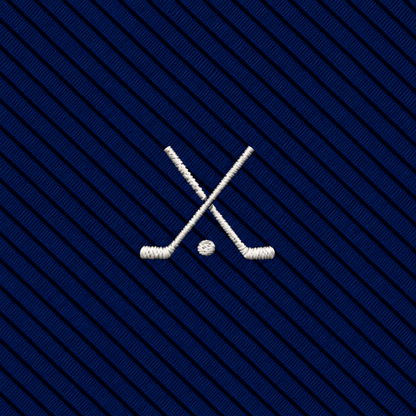 Two crossed ice hockey sticks and a puck embroidered in white on a dark blue diagonally striped fabric background, offering the same refined appeal as a novelty golf tie, but with a classic ice hockey twist.