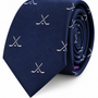 Presenting the Crossed Ice Hockey Skinny Tie: a navy blue tie adorned with a pattern of crossed white hockey sticks, shown rolled neatly against a white background—an ideal sports accessory for any dedicated fan.