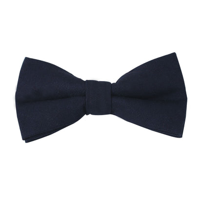 Set against a crisp white background, the Dark Forest Navy Cotton Bow Tie & Pocket Square Set exudes timeless elegance with its smooth, symmetrical shape, adding classic sophistication to any ensemble.