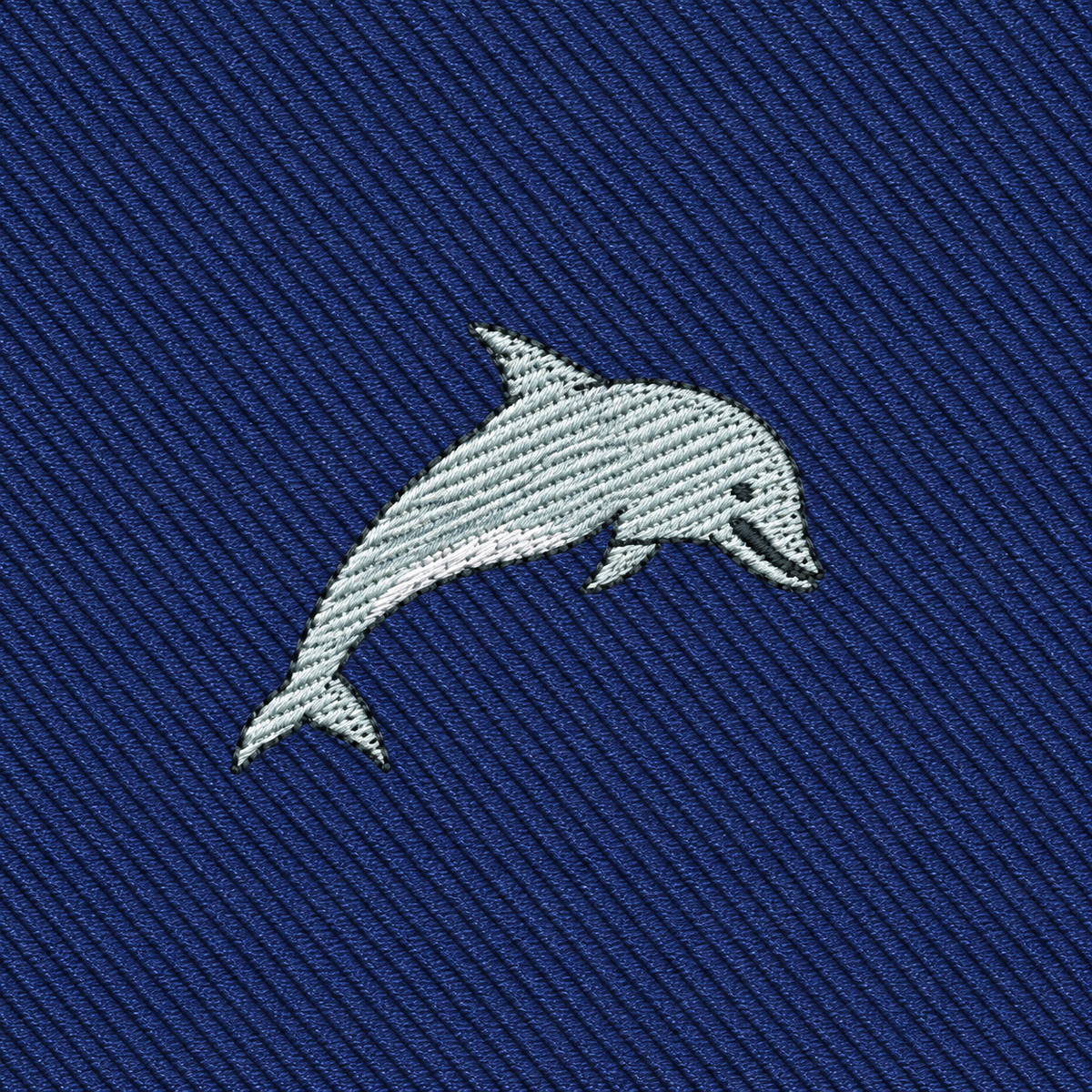 Showcase your style with the Dolphin Skinny Tie, featuring an embroidered gray dolphin on a textured blue fabric—perfect for anyone seeking unique, marine-inspired fashion accessories.