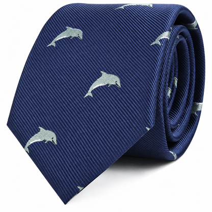 The Dolphin Skinny Tie is a rolled-up navy blue accessory featuring a pattern of small, light-colored dolphins—a marine-inspired tie perfect for anyone seeking unique fashion accessories.