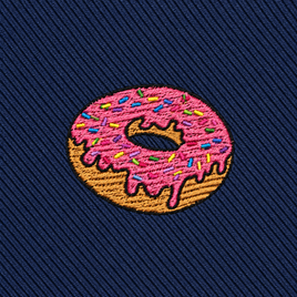 Donut Skinny Tie featuring an embroidered patch of a donut with pink icing and colorful sprinkles on dark blue, diagonal textured fabric—a fun dessert-themed accessory that makes the perfect gift for food lovers.
