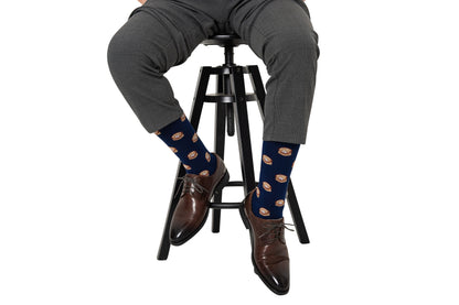 A man sitting on a stool wearing Dumpling Socks.