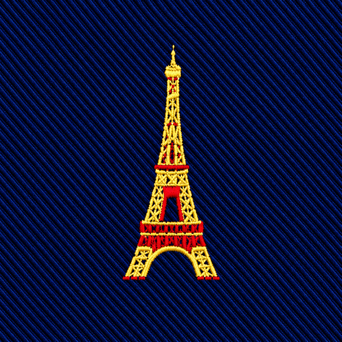 An embroidered yellow and red Eiffel Tower icon on a dark blue ribbed Eiffel Tower Skinny Tie.