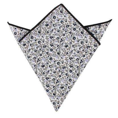 A folded pocket square featuring subtle florals in blue and black on a pristine white background, accentuated by sleek black piping along the edges from the Black Print Floral Cotton Skinny Tie & Pocket Square Set.