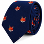 A rolled navy blue Fox Head Skinny Tie featuring a repeating design of orange fox faces.