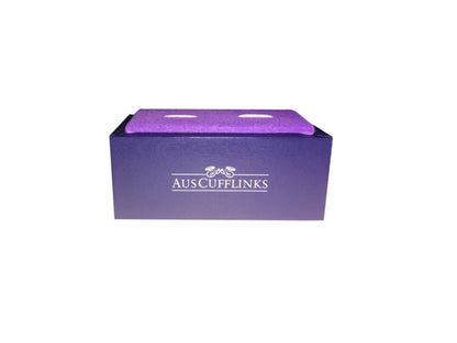 A purple cufflink box featuring the "AUS CUFFLINKS" logo on the side, exuding a regal charm that beautifully contrasts with its sleek design, makes a perfect home for the Gold on Black Cufflinks.