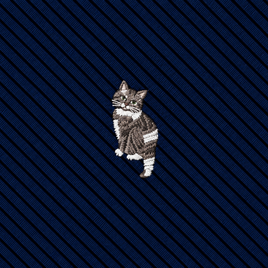 Introducing the Misty Cat Skinny Tie—featuring an embroidered gray tabby cat on dark blue fabric with a stylish diagonal striped texture. This is the perfect accessory for anyone seeking a distinctive cat print tie or a charming cat-themed gift.
