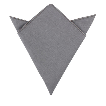 A versatile pocket square from the Grey Cotton Skinny Tie & Pocket Square Set, featuring pointed tips and neatly folded against a white background, adds a touch of style to any combo.
