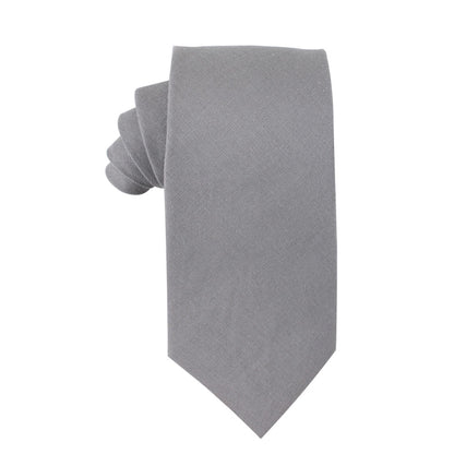 A neatly rolled Grey Cotton Skinny Tie from the Grey Cotton Skinny Tie & Pocket Square Set, featuring a matte finish and showcasing its versatile style against a plain white background.