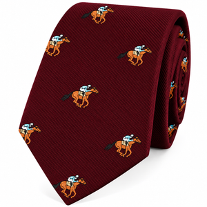 Introducing the Horse Racing Skinny MAROON Tie—a maroon tie adorned with a repeating jockey print, featuring riders on horses embroidered in orange, white, black, and green. This skinny tie brings a playful yet refined accent to any outfit.