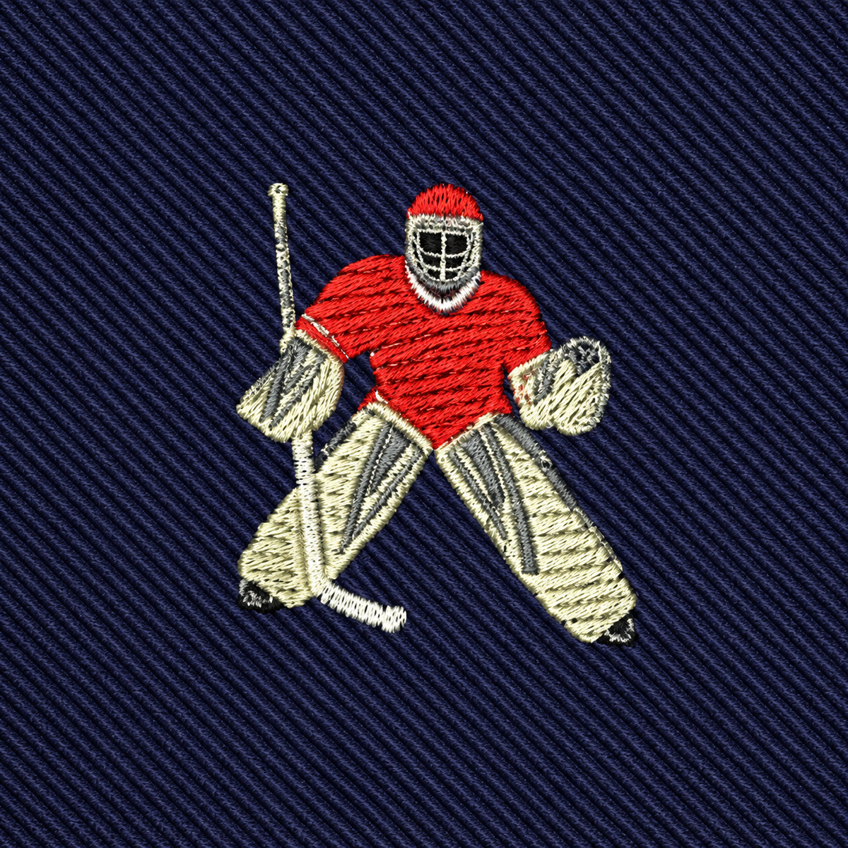 Embroidered with the image of a hockey goalie in red gear holding a stick, this Ice Hockey Goalie Skinny Tie features a dark blue, diagonally-striped fabric background—making it an ideal men’s hockey apparel piece and the perfect gift for goalies.