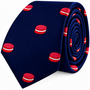 Coiled navy blue Macaron Skinny Tie featuring a pattern of red and white macarons.