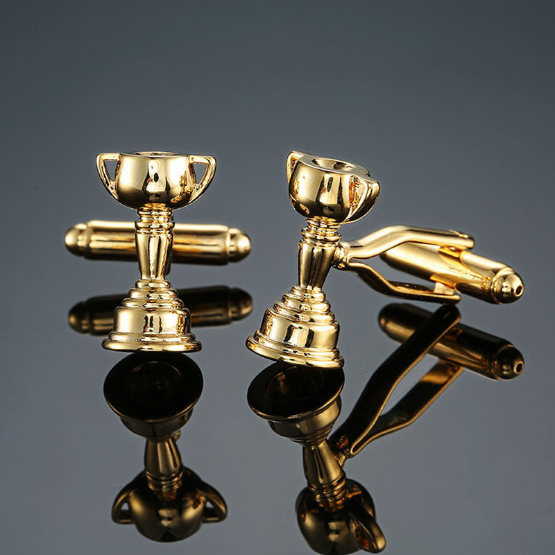 The Melbourne Cup Horse Racing Trophy Cufflinks, gold-toned and trophy-shaped, are perfect for racing fans and displayed elegantly on a reflective black surface.