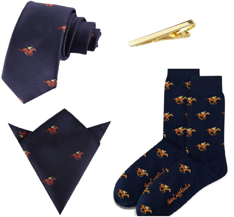 The Melbourne Race Horse Bundle includes a navy tie, pocket square, and socks with orange horse motifs plus a gold tie clip—perfect for any horse racing gift occasion. Displayed on a white background, it’s ideal for enthusiasts.