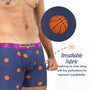 Man wears Basketball Underwear featuring a navy blue design with orange basketball prints. The breathable fabric and perforated inner lining deliver maximum airflow and comfort, making these athletic underwear ideal for sports activities.