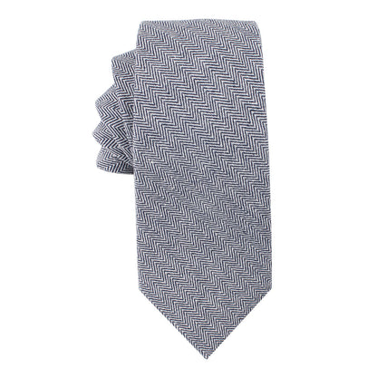 The Navy Blue Herringbone Skinny Cotton Tie from the tie and pocket square set exudes sophistication with its elegant pattern on a white background.