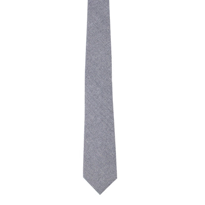 A navy blue skinny cotton tie featuring a subtle herringbone pattern exudes sophistication against a white background.