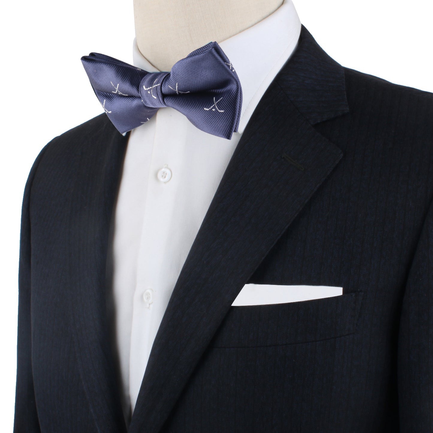 A mannequin dressed in a dark suit, white shirt, and the Ice Hockey Cross Bow Tie brings a sporty flair, complemented by a crisp white pocket square.
