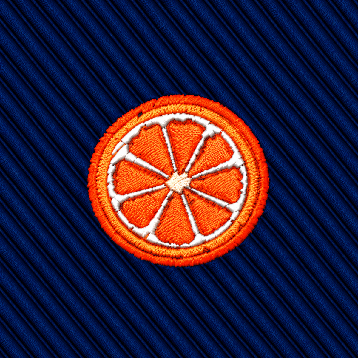 Orange Skinny Tie featuring an embroidered orange slice patch on a dark blue ribbed background.