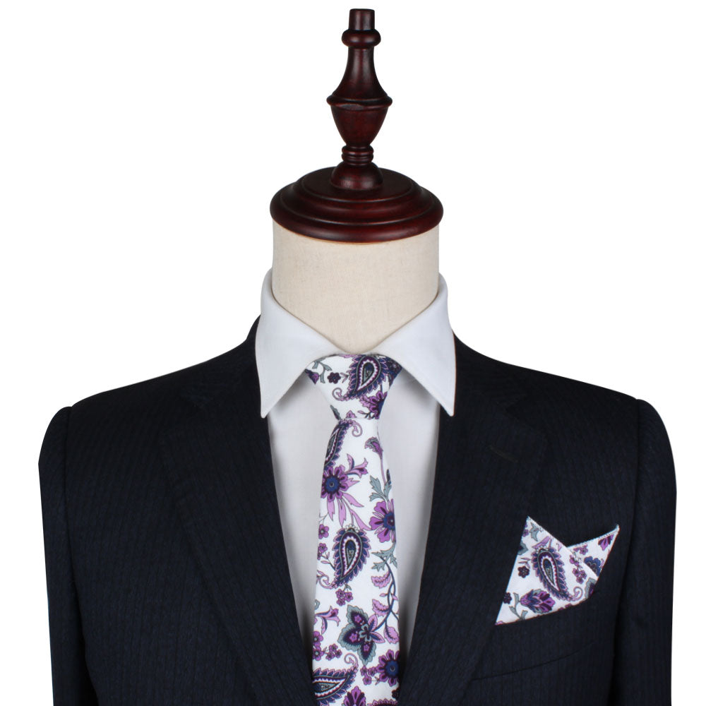 A mannequin displays a black pinstripe suit and white dress shirt, paired with the Purple Floral White Paisley Skinny Tie—an elegant men’s formalwear accessory that’s also perfect as a wedding tie.