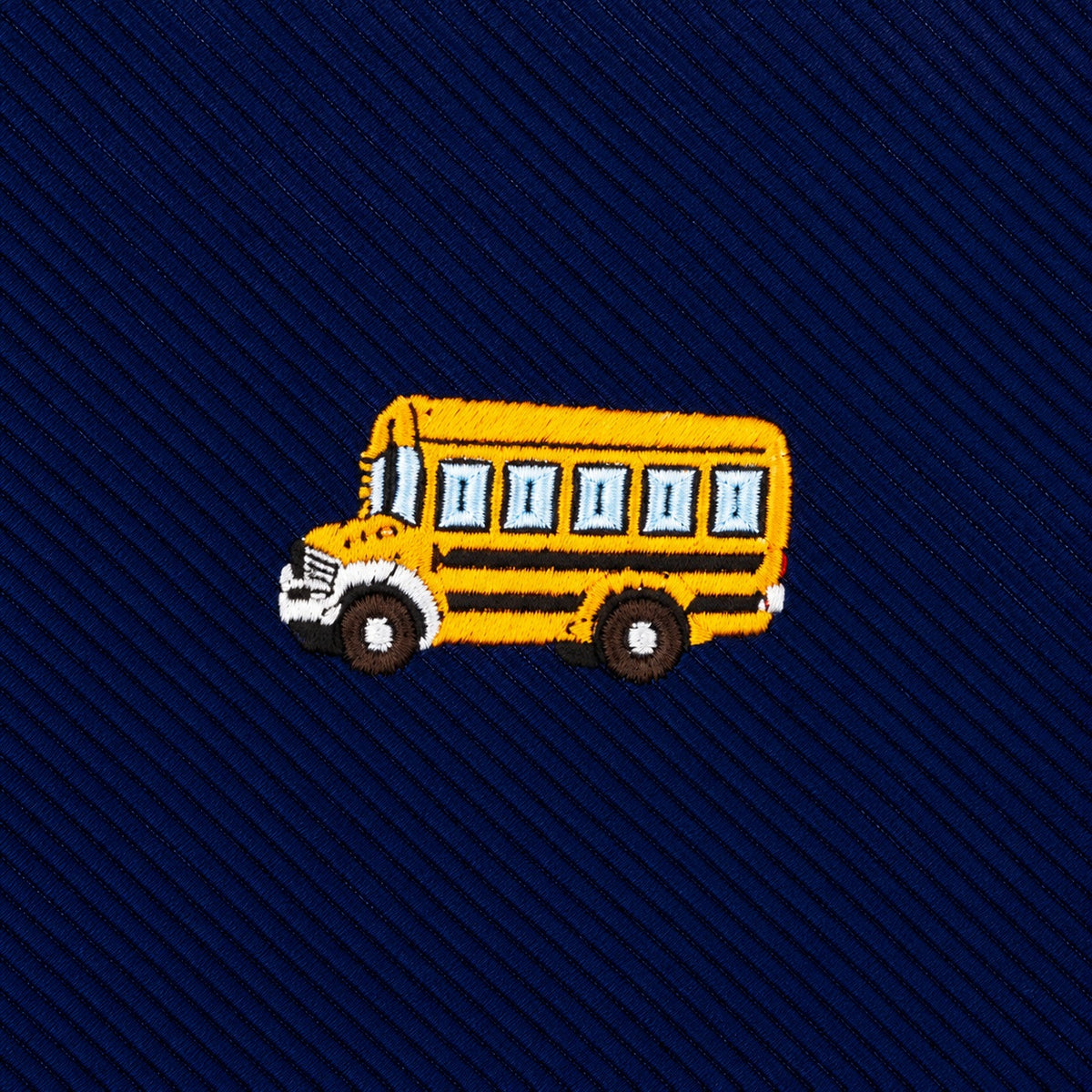 A navy blue School Bus Skinny Tie featuring diagonal stripes and an embroidered yellow school bus in the center.