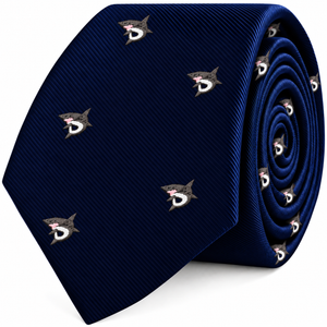 A coiled navy blue Great White Shark Skinny Tie featuring a repeated pattern of small, embroidered sharks.