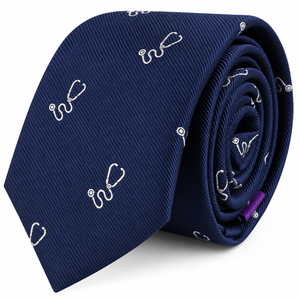 The Stethoscope Skinny Tie is a navy blue necktie featuring a subtle white stethoscope pattern, rolled with the pointed end facing forward—an ideal accessory for medical professionals seeking a refined touch.