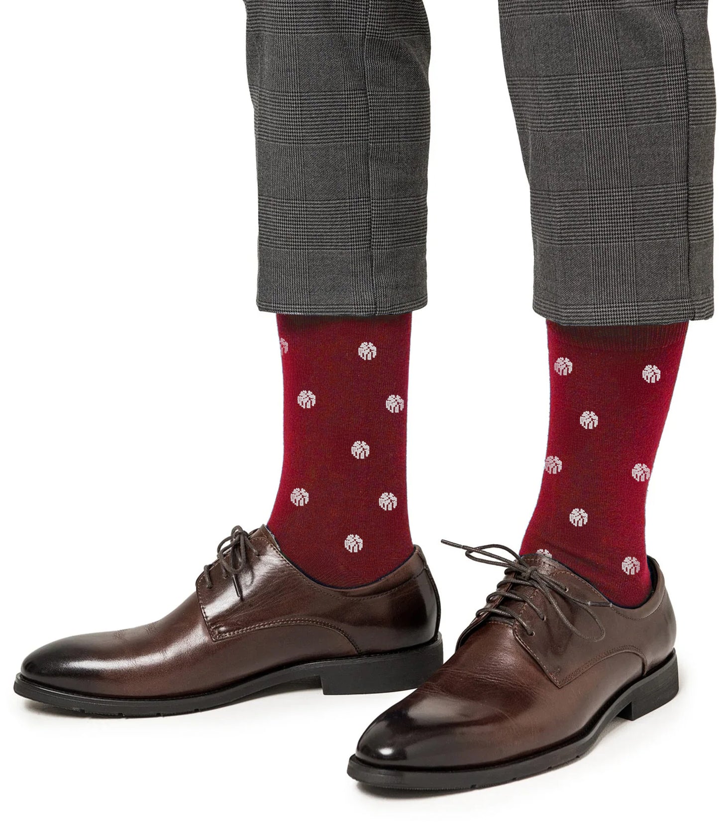 A person shown from the calves down wears brown dress shoes, gray plaid pants, and white basketball socks.