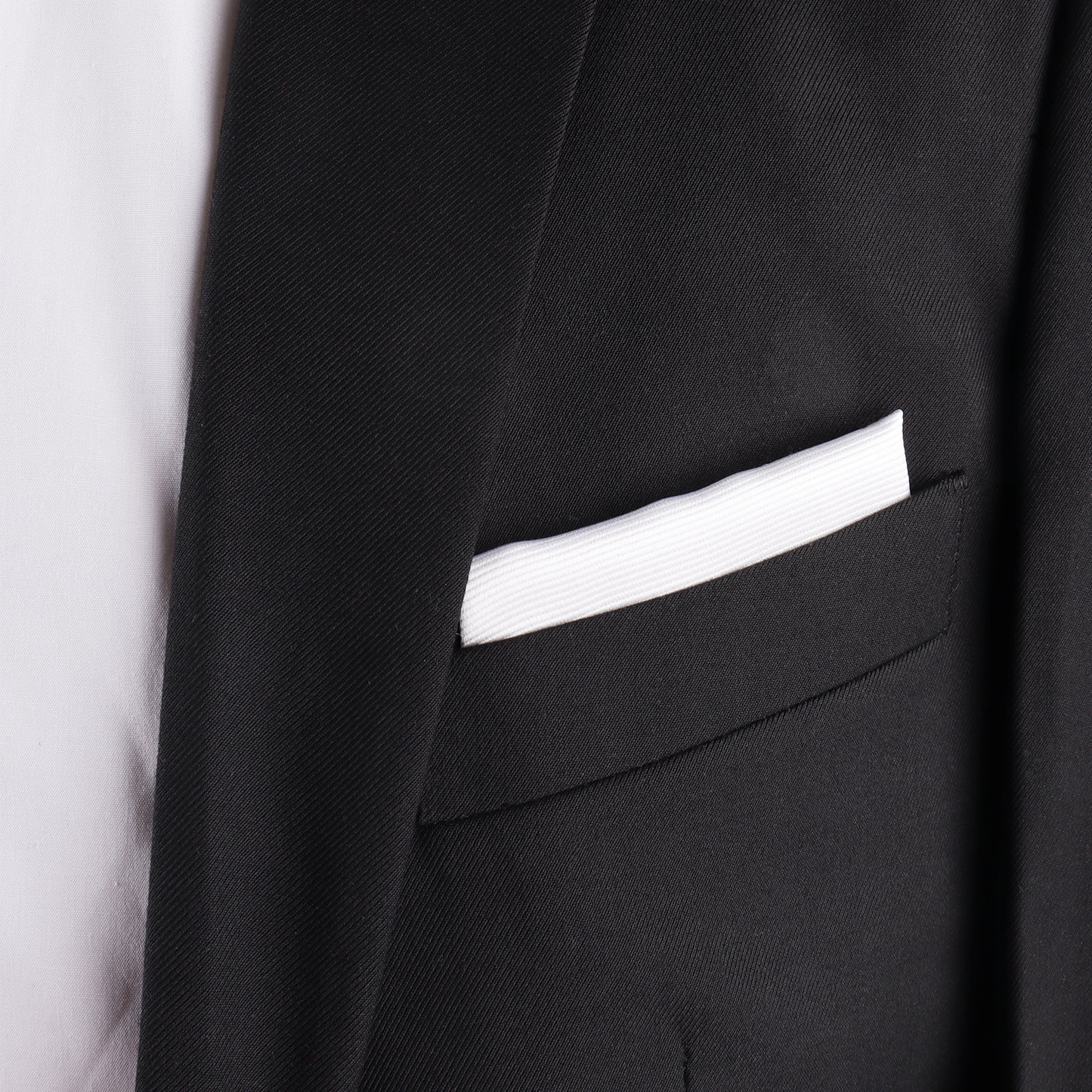 Close-up of a black suit jacket radiating elegance, featuring a White Silk Handkerchief neatly placed in the breast pocket.